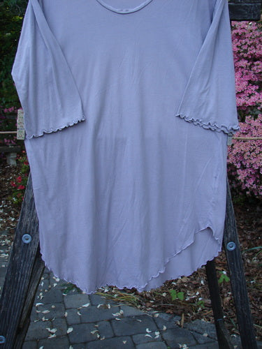 Barclay Batiste Round Bottom Shirt Unpainted Lavender Size 1 displayed on a wooden stand, featuring a deep neckline, curly edgings, three-quarter sleeves, and a rounded hemline.