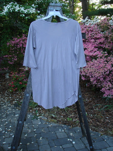 Barclay Batiste Round Bottom Shirt Unpainted Lavender Size 1 on a wooden stand, showcasing its deep neckline, curly edgings, drop shoulders, and three-quarter length sleeves.