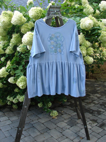 Image alt text: Barclay Collector's Tunic Dress, faded sky, size 2, with rounded neckline, drop waistline, painted pockets, flouncy lower skirt, starburst paint, and dandelion flower flounce.