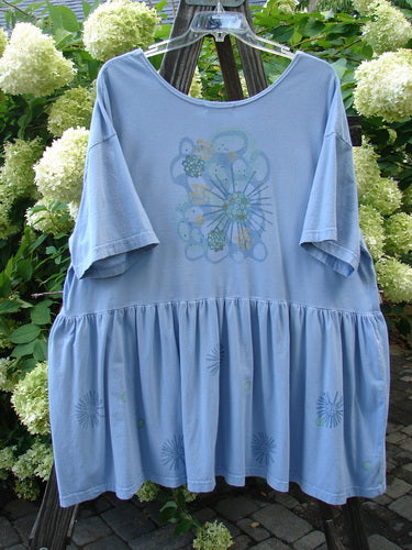 Barclay Collector's Tunic Dress Starburst Faded Sky Size 2: A blue shirt on a clothes rack with a drop waistline, exterior painted pockets, and a flouncy lower skirt.
