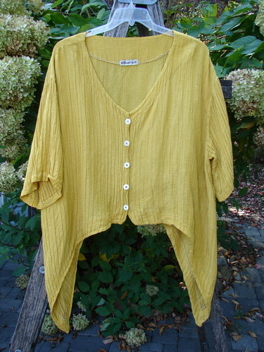 Barclay Rib Silk Dip Side Button Jacket in Golden Sunshine, showcasing a crinkle texture, V-neck, pearl buttons, asymmetrical hem, and three-quarter sleeves, exemplifies BlueFishFinder's unique, vintage-inspired collection.