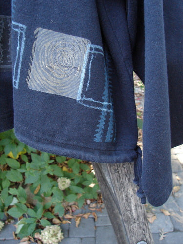 1999 Interlock Side Tie Jacket Fall Grid Black Size 2 draped outdoors; features a geometric hem pattern, wide A-line shape, drawstring detail, and unique button front. Perfectly embodies Bluefishfinder.com's vintage creative expression.