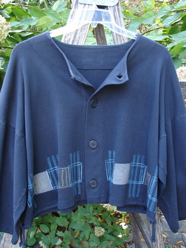 1999 Interlock Side Tie Jacket Fall Grid Black Size 2, featuring a dark-blue boxy cropped design, wide three-quarter sleeves, with lighter blue and gray appliqué accents. Hangs on a clear plastic hanger outdoors.