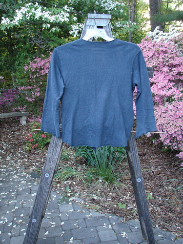 Barclay Hemp Cotton Long Pinch Sleeved Shrug Unpainted Navy Size 1 displayed on a wooden rack, showcasing its deep V neckline, front tie wrap, seamless back, and curly edge details.