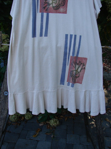 1996 Butterfly Dress Garden Path Birch Bark Size 1, showcasing a cream tunic with ruffled hem and sleeves, blue vertical stripes, red-toned squares featuring abstract black botanicals, hanging outdoors.