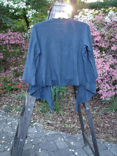 Barclay Hemp Cotton Long Pinch Sleeved Shrug Unpainted Navy Size 1 displayed on a wooden stand, showcasing its deep V neckline, front tie wrap, and pinched sleeves.