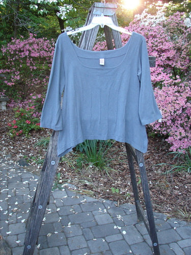 Barclay Cotton Lycra Square Neck Pinch Pullover Unpainted Grey Sky Size 1 displayed on a wooden easel, highlighting its wide square neckline, vertical pinch accents, and varying hemline.