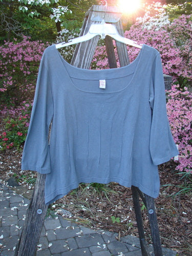 Barclay Cotton Lycra Square Neck Pinch Pullover Unpainted Grey Sky Size 1 displayed on a wooden rack, showcasing its wide square neckline, vertical pinch accents, and three-quarter length sleeves.