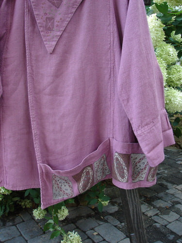 A close-up of the Barclay Hemp Vienna Toggle Collar Jacket in Step Stone Peony. Features include a folded layered neckline with an oversized wooden toggle, a fold-over front, varying hemline with horizontal pockets, sectional panels, and a rear rounded collar. Made from heavy hemp linen, this jacket has a weighted feel and durable texture. Available in size 2.