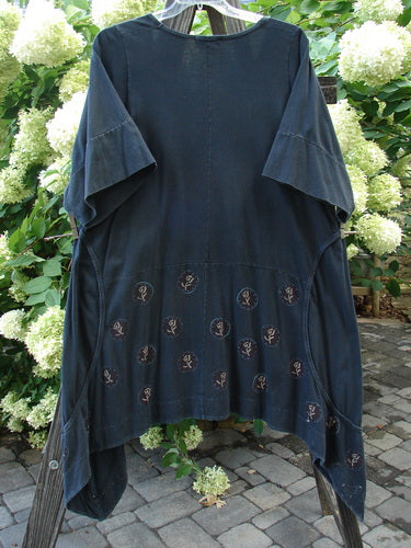 A Barclay Double Pocket Bounce Tunic Dress in Rose Faded Black, size 2. This dress features wrap-around side curvy sectional exterior seams, horizontal front and rear panels, and two oversized front drop bushel pockets. The dress has a dramatic upward scooped hemline with exterior circle stitchery and a deeper oval neckline. The dress is made from medium weight organic cotton and has an overall even fade and light wear.