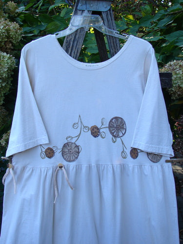 1994 Flower Garden Dress Garden Trail Altered Ecru Size 2, featuring elbow-length sleeves and a drawstring waist with brown floral motif, displayed against greenery, embodying Blue Fish Clothing's vintage, whimsical style.