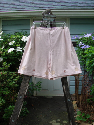 Vintage 1994 Bushel Pocket Garden Short in Pink Granite on a wooden ladder. Features drawstring waist, bushel pockets, double panel, and floral theme paint. From BlueFishFinder's collection of unique Blue Fish Clothing.