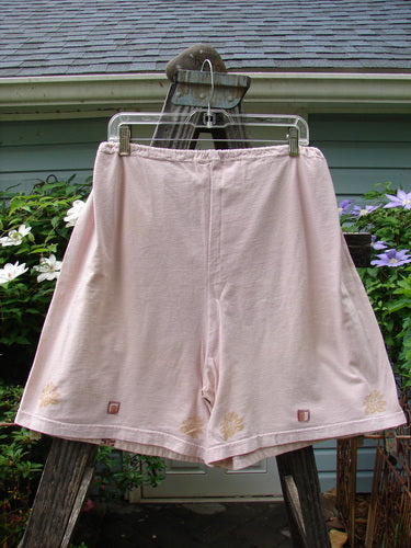 Vintage 1994 Bushel Pocket Garden Short in Pink Granite on a clothes rack. Features drawstring waist, bushel front pockets, double panel, and floral theme. From BlueFishFinder's Summer Collection. Size 1.