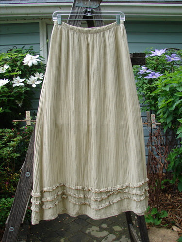 Barclay Rib Silk Triple Ruffle A Line Skirt in Sand, Size 0, hanging on a clothesline. Features a fluttery triple ruffle design, elastic waist, and silken texture. Length: 38 inches. Vintage Blue Fish Clothing at BlueFishFinder.com.