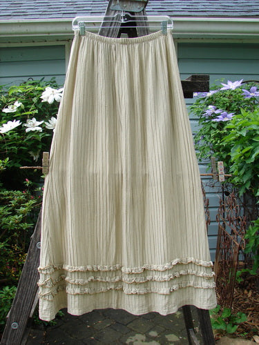 Barclay Rib Silk Triple Ruffle A Line Skirt in Sand, Size 0, elegantly displayed on a clothes rack. Features a fluttery triple ruffle bottom, silken texture, and elastic waistline. Length: 38 inches. Vintage Blue Fish Clothing at BlueFishFinder.com.