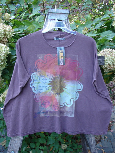 Barclay NWT Cotton Slub Cricket Cap Sleeve Tee Travel By Sun Fig OSFA features a stylized flower graphic on a plum shirt, hanging on a wooden stand with a Blue Fish tag.