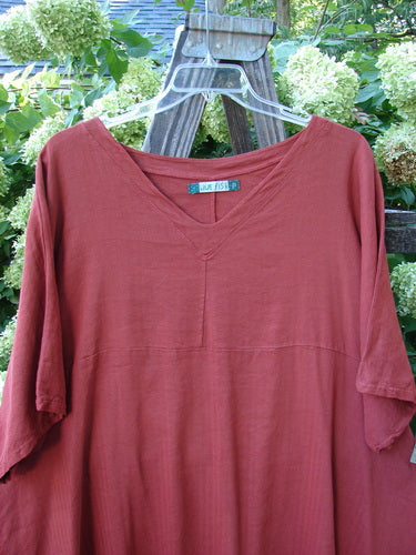 A red Barclay Linen Viscose Vented Urchin Dress in Brick Stripe, size 2, on a clothes rack.