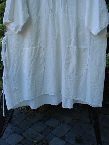 Image alt text: Barclay Linen Duet Sunrise Dress, a white shirt with pockets on a clothesline, made from unusual cotton linen fabric.