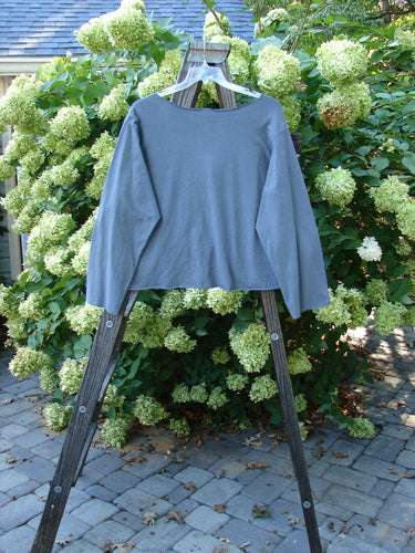 Barclay NWT Layering Cardigan Shrug with rain flower theme paint, on a wooden rack.