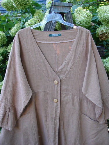 A brown Barclay Linen Adras Uptown Jacket in size 2, featuring a deep V neckline, pleated lower sleeves and hemline, and double drop front pockets. Unpainted for easy layering.
