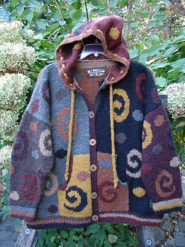 Tara Handknits Hooded Star Button Pocket Cardigan Swirls Brights OSFA features detailed patchwork panels with spiral motifs, star buttons, and a drawcord hoodie, reflecting Bluefishfinder.com's vintage, expressive style.