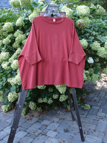 A red Barclay Cotton Lycra Banded Sleeve Dolman Top on a rack, featuring a wide boxy shape, rounded neckline, and banded lower sleeves. Made from heavy-weight organic cotton lycra, this top is in perfect condition. Bust: 80, Waist: 80, Hips: 80, Length: 32 inches.