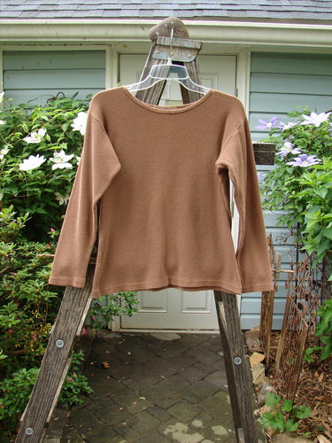 1997 Long Sleeved Thermal Top Unpainted Copper Size 1 displayed on a wooden ladder, showcasing its thick, waffle fabric, continuous neckline stitchery, and slightly tapered waistline.