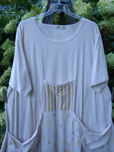 Image alt text: Barclay Farmer Jen Tunic Dress with fallen flower theme, pale pink, size 2, featuring generous measurements, rear elastic tab, oversized bushel front drop pockets, lower bell shape, and deeper rounded neckline.