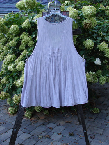 Barclay Gauze Farmer Jen Sleeveless Tunic in Lilac, Size 2, on a wooden rack. Stacked lower pocket ensemble, widening A-line shape, deep V-shaped neckline, and deep arm openings. Unpainted for easy mixing and matching with other Fish Pieces.