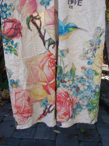 Magnolia Pearl Applique Benjamin Overall in Birdie Bouquet Moon OSFA features vibrant floral and bird motifs on lightweight fabric, hanging outdoors, showcasing a playful, artistic design reflecting BlueFishFinder's vintage-inspired individuality.