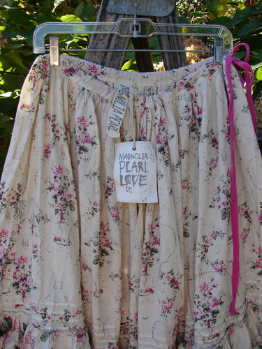 Magnolia Pearl Penelope Skirt Des Rosiers Floral Idealist OSFA features a floral print, gathered waistband, ruffled hem, pintucked accents, and lace details, hanging outdoors with Magnolia Pearl branding visible.