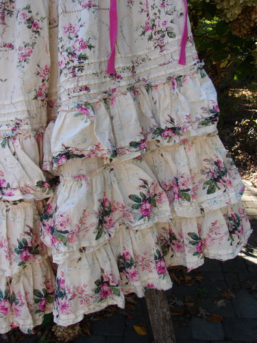 Magnolia Pearl Penelope Skirt in Des Rosiers Floral Idealist displays light cream fabric with pink and green floral motifs, featuring multi-layered ruffles and pink ribbons at the top, epitomizing Bluefishfinder.com's vintage aesthetic.