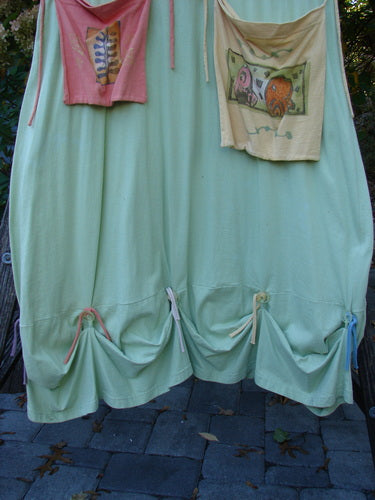 1997 Salt Water Taffy Jumper Sea Life Mellon Size 2 displayed hanging, showcasing its mint-green fabric, gathered hem, and intricate sea life theme paint, embodying BlueFishFinder's vintage, expressive style.