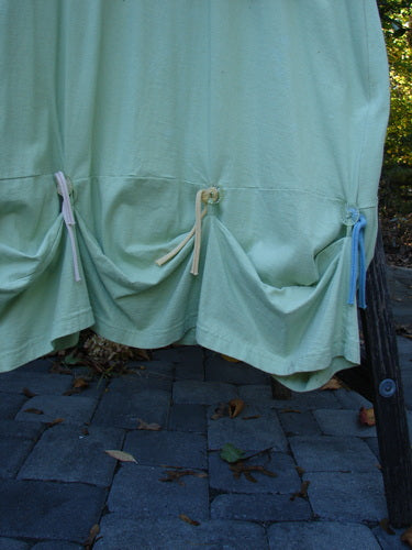 1997 Salt Water Taffy Jumper Sea Life Mellon Size 2 displayed with organic cotton fabric, featuring cinched pouches via colorful ties, metal grommets, and rippie accents, set outdoors on stone pavers.