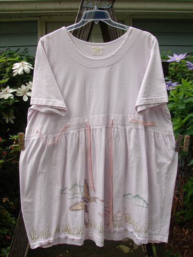 Vintage 1999 Ribbon Dress Butterfly Orchid Size 2 hanging on a clothesline. Features a double paneled waistline with button accents, bell shape, and butterfly theme paint. Bust 54, Waist 54, Hips 60, Length 36.