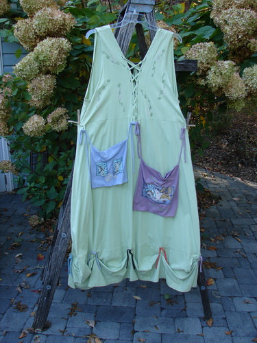 1997 Salt Water Taffy Jumper Sea Life Mellon Size 2 with lace-up V-back, decorative hem ties, and fabric pouches, elegantly displayed outdoors on a wooden ladder, embodying Bluefishfinder.com's vintage charm.