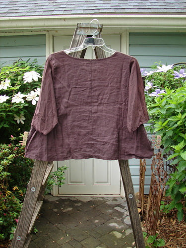 Barclay Cotton Sleeved Linen Crop Top Unpainted Fig Size 1 displayed on a wooden rack with a rounded neckline and three-quarter length sleeves with curly edges.