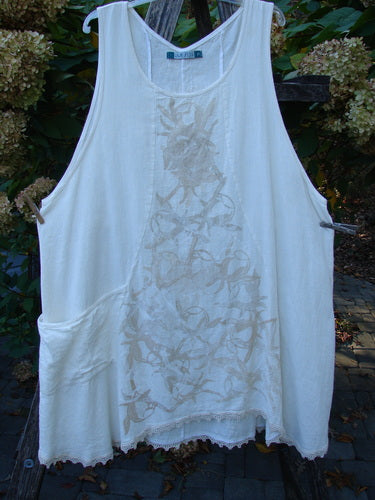 Barclay Slub Figure 8 Lace Pocket Pinafore Dress in Soft Floral Crème, Size 2, featuring a scooped neckline, tonal embroidery, and unique figure eight seams, hanging outdoors on a wooden rack.