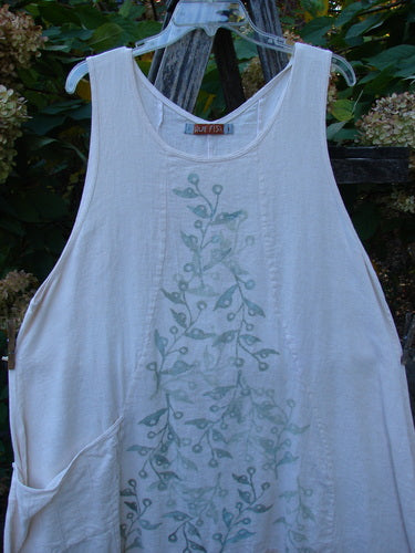 Barclay Slub Figure 8 Lace Pocket Pinafore Dress Soft Floral Crème Size 1, features a sleeveless A-line design with a greenish vine print, round neckline, and side pockets, hanging on a clear hanger.