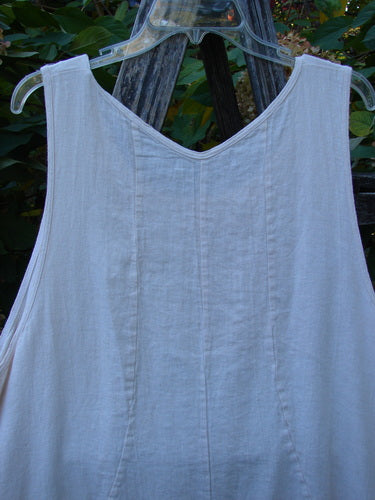 Barclay Slub Figure 8 Lace Pocket Pinafore Dress Soft Floral Crème Size 1, featuring a scooped neckline, vertical seam detailing, and pinched exterior pockets, hanging outdoors on a clear hanger.