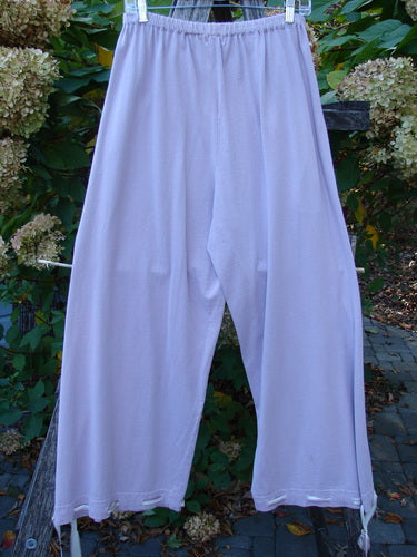1999 Ribbon Pant Unpainted Orchid Size 1 hanging on a clothesline, showcasing loose fit, elastic waist, and draw-string ties. Features playful silk ribbons and bubble cargo pockets, embodying vintage Blue Fish style.