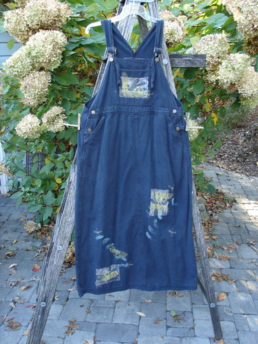 1996 Denim Overall Jumper Truck Travel Black Size 1 displayed on a rustic ladder, featuring adjustable straps, a painted front bib pocket, side metal button closures, and decorative patches, reflecting vintage Blue Fish Clothing.