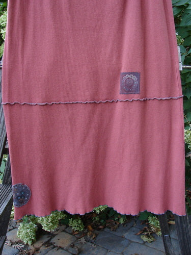 Barclay Patched Fold Over Ruffle Panel Skirt - A skirt on a clothes rack with a pink ruffled edge. Organic cotton thermal fabric.