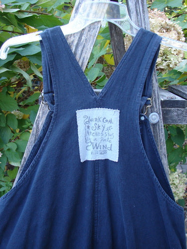 1996 Denim Overall Jumper Truck Travel Black Size 1 on hanger, featuring a painted front bib pocket with hand-drawn text and adjustable shoulder straps, showcasing Blue Fish's creative vintage style.