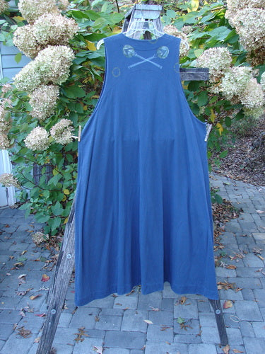 1996 State Fair Vest Directional Arrow Ridge Size 2, a loose-fitting, navy-blue sleeveless smock with a single oversized button, hanging from a wooden ladder, showcasing its wide A-line shape and unique hemline.