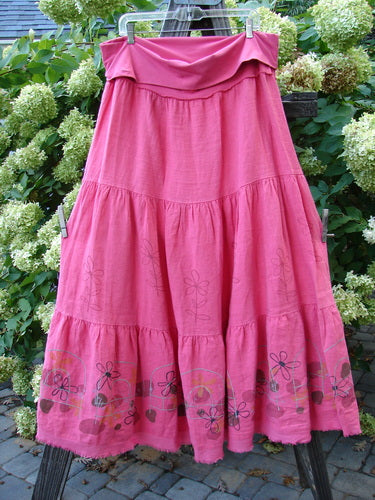 A Barclay Linen Fold Over Three Tier Skirt in Flamingo, featuring a pink skirt with a flower design on a clothesline.