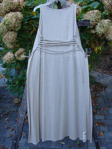 1998 Linen Knit Wrap Dress Unpainted Natural Size 1, elegantly draped on a rustic frame, showcasing its long, slender design with a round neckline and waist ties, embodying timeless BlueFishFinder vintage charm.
