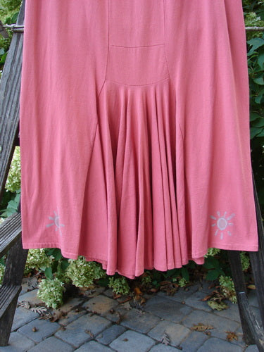 A 1995 Kick Pleat Skirt in Papaya, made from Organic Cotton. Features include a full elastic waist, widening shape, rear kick pleat, and painted travel theme accents.