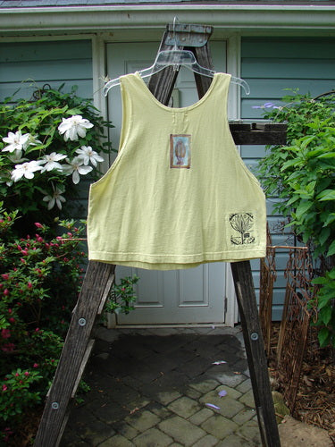 1999 Crop Tank Top Pike Duo Citron Size 0 displayed on a wooden ladder, showcasing its wide, boxy shape, scooped neckline, and vibrant double fish design.