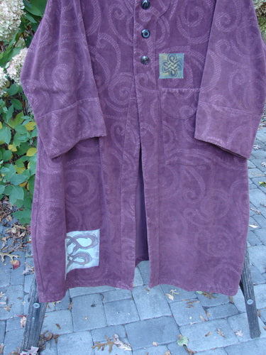 2000 Patched Upholstery Diwmach Coat Celtic Time Aubergine Size 2 with tone-on-tone spiral pattern, vintage buttons, Celtic patches, and scalloped neckline, hanging outdoors against a natural backdrop.